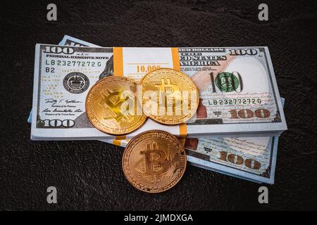 Moneta in metallo bitcoin d'oro su una fattura in dollari USA Foto Stock