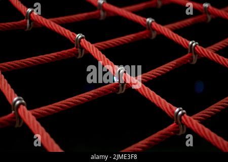 Corde nel parco giochi. Rete da arrampicata, primo piano. Funi fissate con maglie. Foto Stock