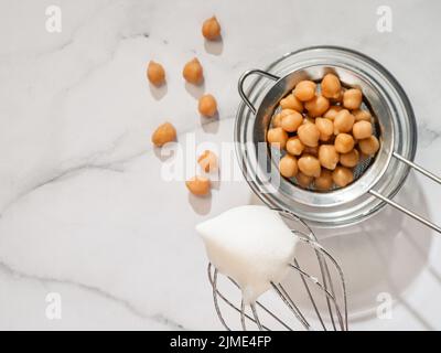 Chickpea aquafaba montata sulla frusta del miscelatore planetario Foto Stock