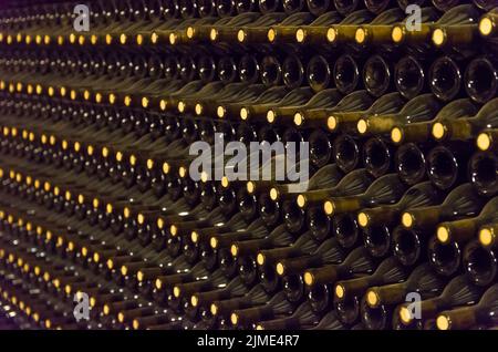 Bottiglie di vino conservate nella cantina sotterranea per la maturazione Foto Stock