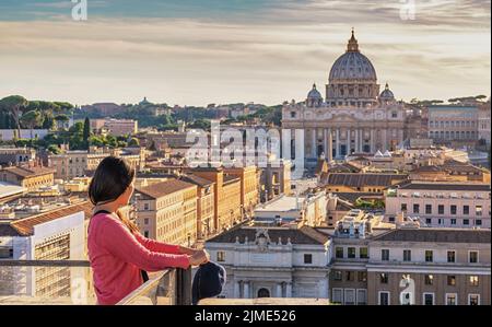 Roma Vaticano Italia vista ad alto angolo tramonto skyline della città con donna turistica Foto Stock