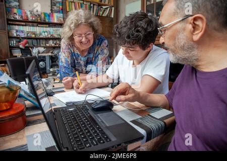 Il ragazzo adolescente sta prendendo le lezioni di matematica dai nonni a casa Foto Stock