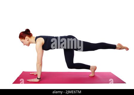 Pilates o yoga. Questa bella donna sottile esegue un esercizio Pilates su un tappetino da palestra. Isolato su sfondo bianco Foto Stock