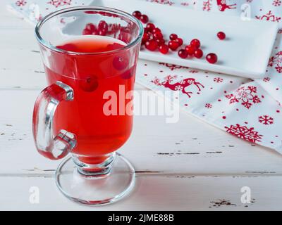 Focalizzazione selettiva sui mirtilli rossi in una bevanda fresca in una tazza di vetro. Foto Stock