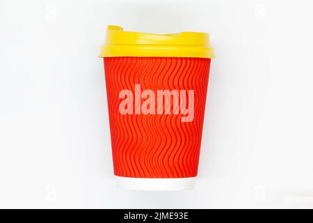 Tazza da caffè di carta. Tazza da caffè in carta rossa con coperchio in plastica gialla. Tazza usa e getta per bere bevande calde e fredde in tutta sicurezza. Capacità nervata sicura. Foto Stock