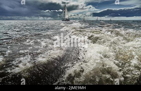 Gara di barche a vela in regata in caso di tempesta, gara, onde grandi, regata di vela, tempo nuvoloso, vela maestra, jib, lavoro di squadra, Foto Stock