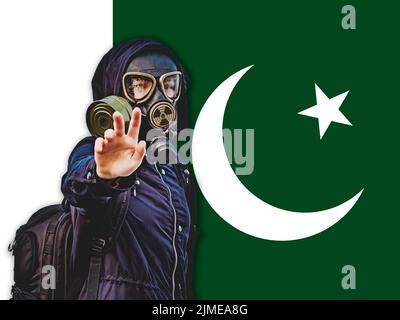 Ragazza in una maschera nera a gas sullo sfondo della bandiera del Pakistan Foto Stock