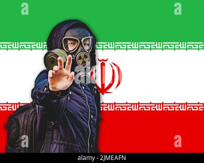 Ragazza in una maschera nera a gas sullo sfondo della bandiera dell'Iran Foto Stock