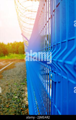 Recinzioni metalliche dell'impianto di produzione con filo spinato lungo il perimetro. Foto Stock