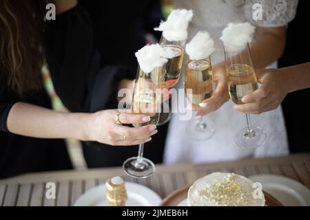 Le ragazze tengono i bicchieri di vino. Dettagli della festa. Festa di nozze. Bere alcol. Foto Stock