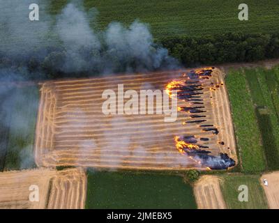 Appezzamento di terreno con paglia, incendio nel campo, combustione di residui di paglia, inquinamento dell'aria ambientale Foto Stock