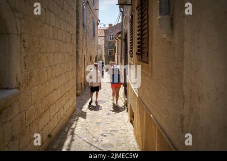 Turisti in uno stretto vicolo nella città vecchia di Krk in Croazia Foto Stock