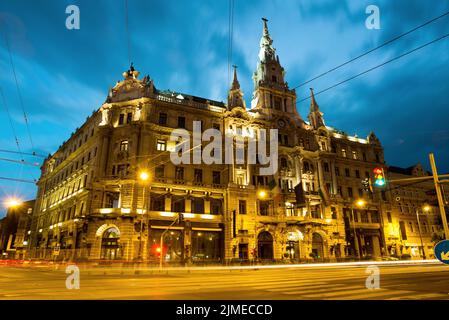 Vista notturna dell'edificio storico che ospita il New York Cafe a Budapest Foto Stock