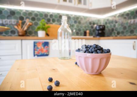 Ciotola di mirtilli freschi sul tavolo da cucina rustico Foto Stock