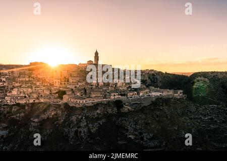 Sole splendente che tramonta su Matera, città di pietra e patria del pistacchio, Italia Foto Stock
