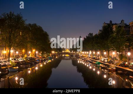 Canale notturno di Amsterdam con barche e auto parcheggiate Foto Stock