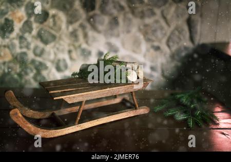 Slitta di Natale di fronte al muro di pietra. Sfondo tempo inerte. Foto Stock