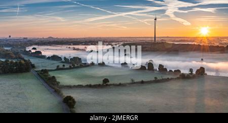 Alba e i primi raggi di sole sui prati coperti di nebbia della Ruhr a Duisburg, Germania Foto Stock