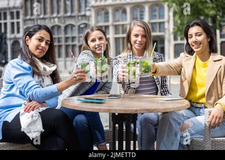 21 maggio 2021, Anversa, Belgio, quattro attraenti giovani donne di gara mista brinda con un cocktail all'aperto nel centro della città af Foto Stock