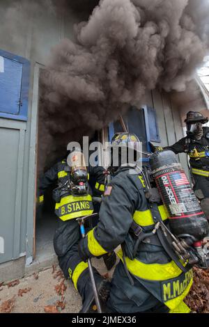 I vigili del fuoco entrano in un edificio come membri del Dipartimento dei vigili del fuoco di East Hampton, insieme ai membri del Dipartimento dei vigili del fuoco di Springs e di Amaganse Foto Stock