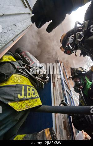 I vigili del fuoco entrano in un edificio come membri del Dipartimento dei vigili del fuoco di East Hampton, insieme ai membri del Dipartimento dei vigili del fuoco di Springs e di Amaganse Foto Stock