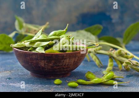 Fagioli di soia verdi crudi edamame. Edamame, soia verde fresca in cialda. Cibo vegano sano. Foto Stock