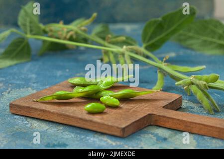 Fagioli di soia verdi crudi edamame. Edamame, soia verde fresca in cialda. Cibo vegano sano. Foto Stock