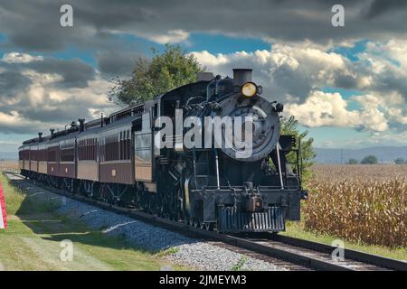 Vista di un treno passeggeri antico che si avvicina con le vetture restaurate Foto Stock