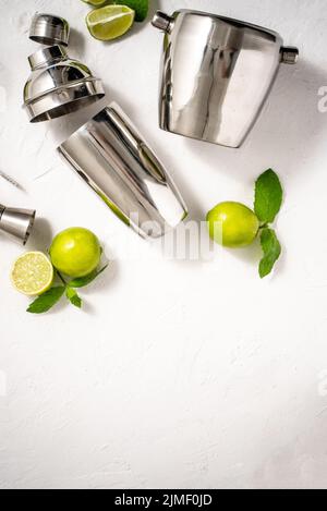 Vista dall'alto del set di utensili da coda per baristi. Agitatore in acciaio, misura, pinza con calce Foto Stock