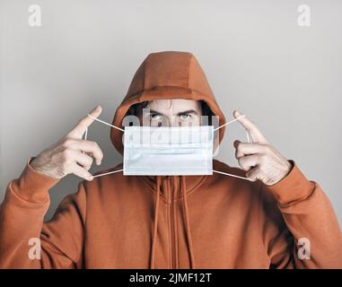 L'uomo mette la maschera medica Foto Stock