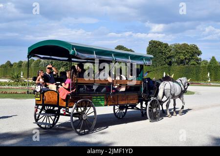 Vienna, Austria - 01 agosto 2022: Turisti non identificati in una carrozza trainata da cavalli nel Parco di Schoenbrunn - ex residenza dei governanti asburgici e a. Foto Stock