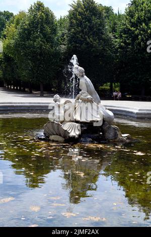 Vienna, Austria - 01 agosto 2022: Persone non identificate riposano su panchina alla fontana naiad occidentale in un rondeau lungo i viali alberati nel parco o Foto Stock