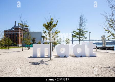 Lisbona, PORTOGALLO - 2 luglio 2022: Grandi lettere 'maat' all'ingresso della moderna area museale MAAT a Lisbona, Portogallo. Sullo sfondo il ponte Foto Stock