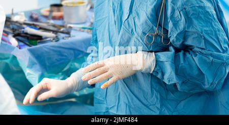 Focalizzazione selettiva sulle mani di un chirurgo in guanti chirurgici sterili Foto Stock