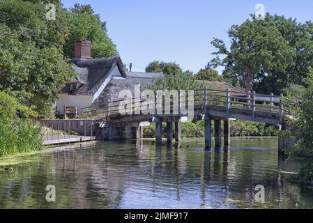 ponte ad arco in legno e cottage con tetto in paglia a flatford, suffolk Foto Stock