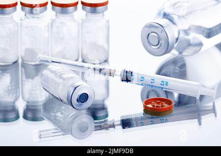 Polvere di farmaco in flaconcino come dose di vaccino vaccino vaccino vaccino antinfluenzale shot insieme con siringa per iniezione trattamento sul tavolo medico. Vaccinazione o immun Foto Stock