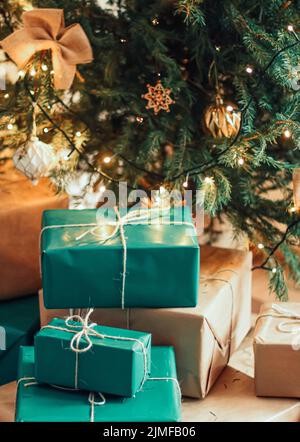 Consegna delle feste di Natale e concetto di regali sostenibili. Confezioni regalo blu verde confezionate in confezioni eco-compatibili e riciclate Foto Stock