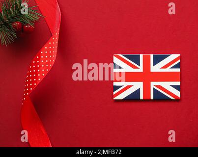 Tradizione britannica di Natale e design di vacanza concetto. Bandiera di Union Jack della Gran Bretagna e ornamenti e decorazioni natalizie su re Foto Stock