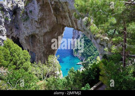 Vista sulla porta rocciosa Arco Naturale sulla ripida costa dell'isola di Capri, Golfo di Napoli, Campania, Italia, Europa Foto Stock