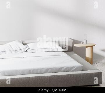 Camera con letto e cuscini e comodino con parete bianca su sfondo, 3D rendering Foto Stock