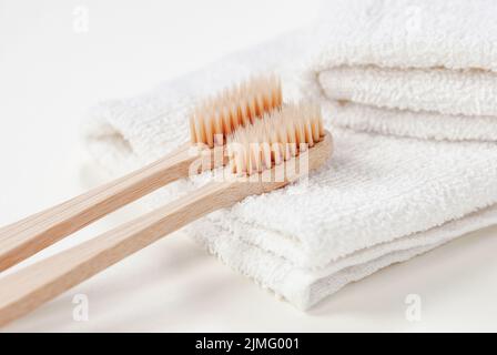 Spazzolini da denti in bambù con setole a base vegetale su asciugamano bianco, spazzolino biologico biodegradabile da primo piano Foto Stock