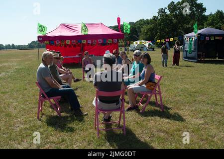 Runnymede, Surrey, Regno Unito. 6th Agosto 2022. Estinzione Rebellion Sud Est si accampavano al luogo di nascita della democrazia a Runnymede oggi, dove la Magna carta fu firmata oltre 800 anni fa. Presso il sito del National Trust, sedevano sulle proprie sedie giurate e sulle famose sedie in bronzo scolpite dei 12 giurati. Andarono anche al Magna carta Memorial. I bambini stavano facendo stampe murali e chiacchieravano con i membri del pubblico sulla loro campagna di disobbedienza civile e invitavano il governo ad agire con urgenza sull'emergenza climatica. Credit: Maureen McLean/Alamy Live News Foto Stock