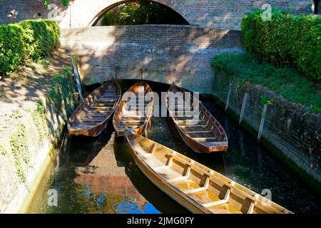 Una vista panoramica di un piccolo ponte, barche di legno (Ulmer Schachteln) sotto di esso, alberi verdi e le mura della città vecchia nella città di Ulm in Germania Foto Stock