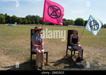 Runnymede, Surrey, Regno Unito. 6th Agosto 2022. Estinzione Rebellion Sud Est si accampavano al luogo di nascita della democrazia a Runnymede oggi, dove la Magna carta fu firmata oltre 800 anni fa. Presso il sito del National Trust, sedevano sulle proprie sedie giurate e sulle famose sedie in bronzo scolpite dei 12 giurati. Andarono anche al Magna carta Memorial. I bambini stavano facendo stampe murali e chiacchieravano con i membri del pubblico sulla loro campagna di disobbedienza civile e invitavano il governo ad agire con urgenza sull'emergenza climatica. Credit: Maureen McLean/Alamy Live News Foto Stock