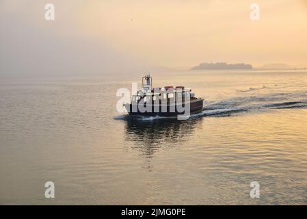 Il piccolo traghetto passeggeri Brownsea Enterprise si avvicina al molo di Haven, Poole, in una serata di maggio nebbiosa Foto Stock