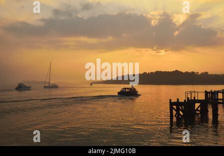 Il piccolo traghetto passeggeri Brownsea Enterprise lascia il molo a Haven, Poole, e si dirige verso Brownsea Island in una nebbiosa serata di maggio Foto Stock