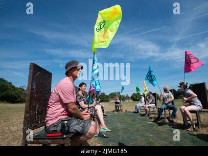 Runnymede, Surrey, Regno Unito. 6th Agosto 2022. Estinzione Rebellion Sud Est si accampavano al luogo di nascita della democrazia a Runnymede oggi, dove la Magna carta fu firmata oltre 800 anni fa. Presso il sito del National Trust, sedevano sulle proprie sedie giurate e sulle famose sedie in bronzo scolpite dei 12 giurati. Andarono anche al Magna carta Memorial. I bambini stavano facendo stampe murali e chiacchieravano con i membri del pubblico sulla loro campagna di disobbedienza civile e invitavano il governo ad agire con urgenza sull'emergenza climatica. Credit: Maureen McLean/Alamy Live News Foto Stock