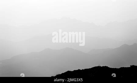 Strati di montagna in bianco e nero. Profilo trasversale. Atmosfera con nebbia, nuvole. Italia. Europa. Foto Stock