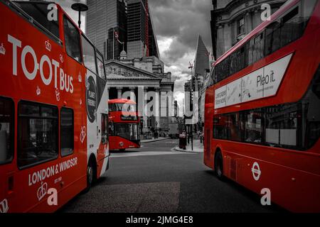 Tre autobus a due piani rossi si incontrano all'incrocio di Bank Station, Londra; colore rosso selettivo della carta da parati a due piani di Londra Foto Stock