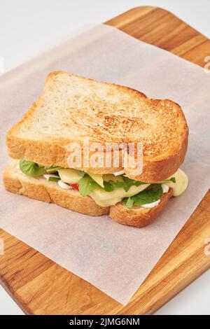 Delizioso panino con verdure sul tagliere Foto Stock